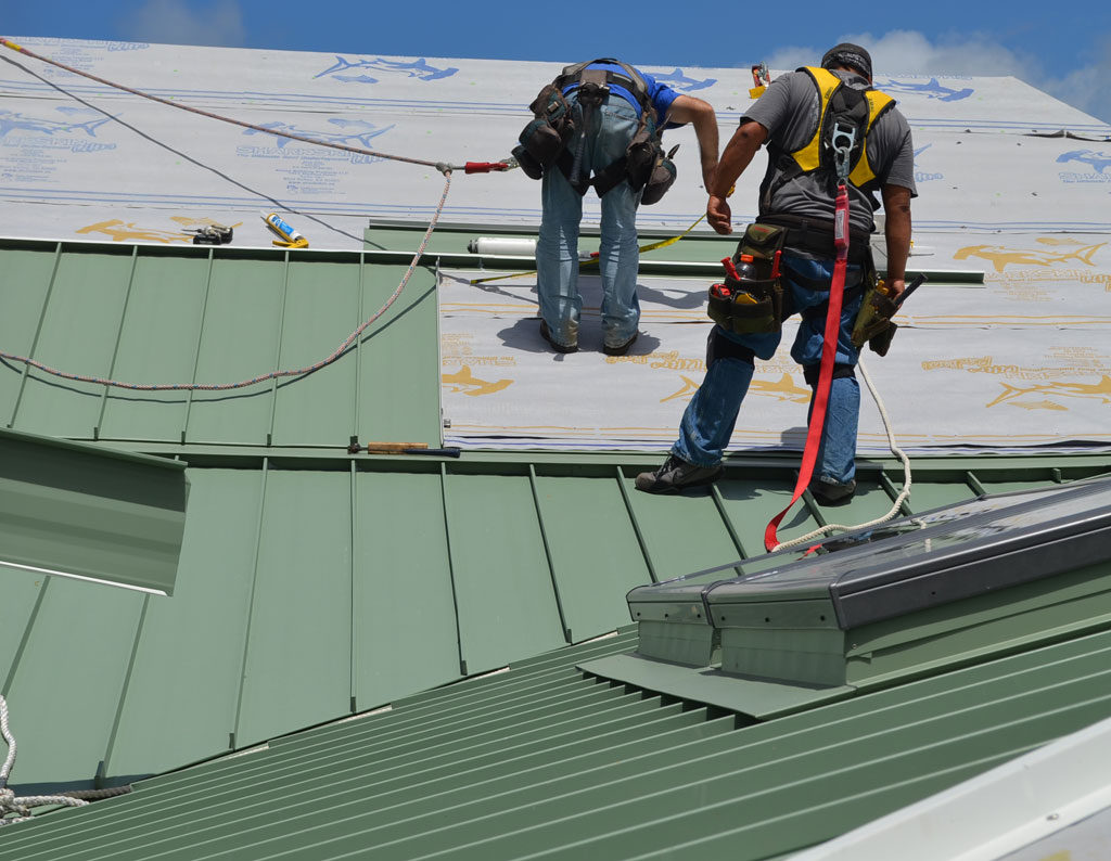 Green standing seam aluminum roof being installed over the Sharkskin Ultra Radiant®